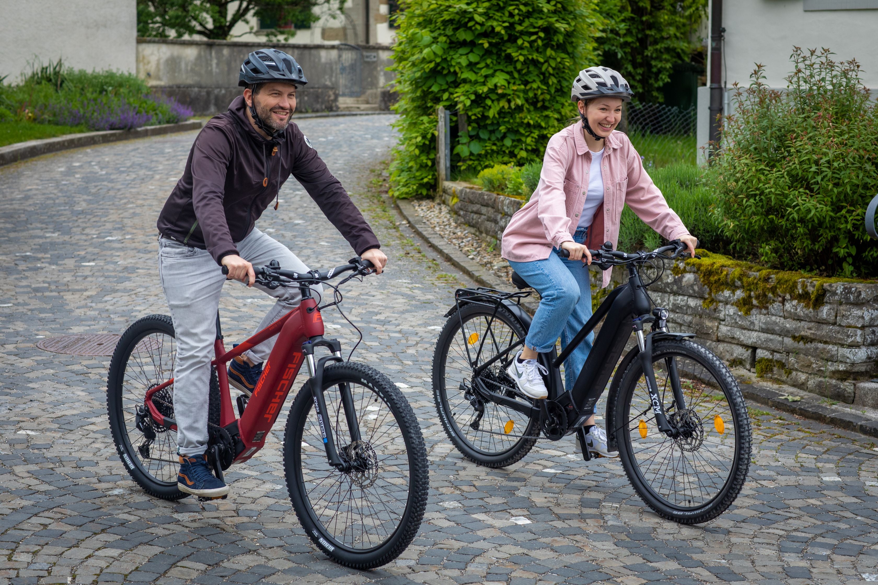 Ein Mann und eine Frau  auf einer E-Bike Fahrradtour mit ihren Fischer ATB Terra E-Bike und MTB Montis im ländlichen Kyburg